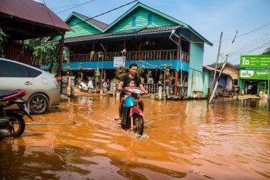 Preak Şvay Köyü, Koh Rong Adası, Kamboçya, 28 Ocak 2025 Köyün ana caddesi yıllık yüksek gelgitler nedeniyle sular altında. Görüş mesafesi sınırlı olduğu için insanlar dikkatli sürüyor..