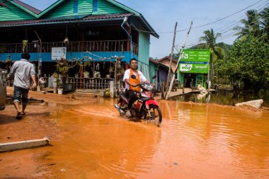 Preak Şvay Köyü, Koh Rong Adası, Kamboçya, 28 Ocak 2025 Köyün ana caddesi yıllık yüksek gelgitler nedeniyle sular altında. Görüş mesafesi sınırlı olduğu için insanlar dikkatli sürüyor..