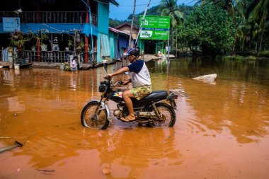 Preak Şvay Köyü, Koh Rong Adası, Kamboçya, 28 Ocak 2025 Köyün ana caddesi yıllık yüksek gelgitler nedeniyle sular altında. Görüş mesafesi sınırlı olduğu için insanlar dikkatli sürüyor..