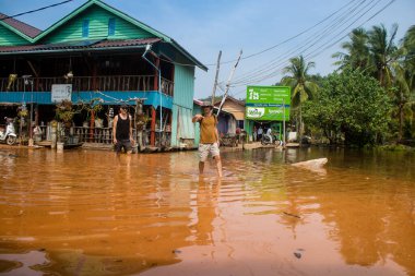 Preak Şvay Köyü, Koh Rong Adası, Kamboçya, 28 Ocak 2025 Köyün ana caddesi yıllık yüksek gelgitler nedeniyle sular altında. Turistler, ayaklarını suya sokarak karşıya geçmek zorundalar..