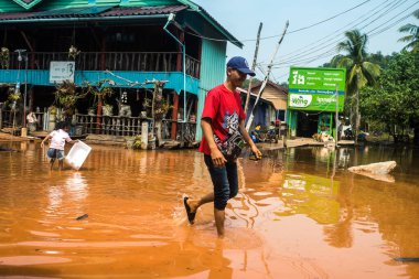 Preak Şvay Köyü, Koh Rong Adası, Kamboçya, 28 Ocak 2025 Köyün ana caddesi yıllık yüksek gelgitler nedeniyle sular altında. Mahalle sakinlerinin ayakları suyun içindeyken karşıya geçmeleri gerekiyor..