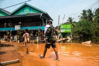 Preak Şvay Köyü, Koh Rong Adası, Kamboçya, 28 Ocak 2025 Köyün ana caddesi yıllık yüksek gelgitler nedeniyle sular altında. Mahalle sakinlerinin ayakları suyun içindeyken karşıya geçmeleri gerekiyor..