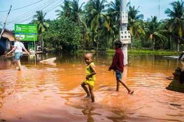 Preak Şvay Köyü, Koh Rong Adası, Kamboçya, 28 Ocak 2025 Köyün ana caddesi yıllık yüksek gelgitler nedeniyle sular altında. Çocuklar durumdan memnun görünüyorlar ve suyu seviyorlar..
