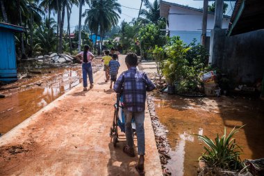 Preak Şvay Köyü, Koh Rong Adası, Kamboçya, 28 Ocak 2025 Köyün ana caddesi yıllık yüksek gelgitler nedeniyle sular altında. Çocuklar durumdan memnun görünüyorlar ve suyu seviyorlar..