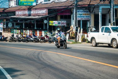 Koh Chang, Tayland, 15 Şubat 2025 Tayland 'da Koh Chang adasının sokaklarında motosikletli insanlar dolaşıyor. Canlı sokak hayatı, zengin kültür mirası ve hareketli pazarlarıyla ünlüdür.