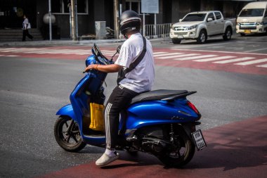 Bangkok, Tayland, 8 Mart 2025 İnsanlar Tayland 'ın başkenti Bangkok sokaklarında motosiklet ve scooter kullanıyor. Bangkok 'un trafik sıkışıklıklarında yol bulmanın en etkili yolu bu..
