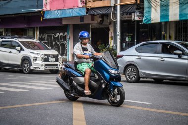 Bangkok, Tayland, 8 Mart 2025 İnsanlar Tayland 'ın başkenti Bangkok sokaklarında motosiklet ve scooter kullanıyor. Bangkok 'un trafik sıkışıklıklarında yol bulmanın en etkili yolu bu..