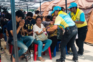 Bangkok, Tayland, 29 Mart 2025. Kayıp işçilerin aileleri, Tayland başkentini deprem vurduktan sonra çöken yüksek binaların bulunduğu bir çadırda bekliyorlar..