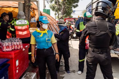 Bangkok, Tayland, 29 Mart 2025. Tayland başkentini deprem vurduktan sonra yıkılan yüksek binadaki kurtarma ekiplerine su ve yiyecek getiren gönüllüler..