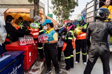 Bangkok, Tayland, 29 Mart 2025. Tayland başkentini deprem vurduktan sonra yıkılan yüksek binadaki kurtarma ekiplerine su ve yiyecek getiren gönüllüler..
