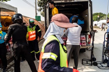 Bangkok, Tayland, 29 Mart 2025. Tayland başkentini deprem vurduktan sonra yıkılan yüksek binadaki kurtarma ekiplerine su ve yiyecek getiren gönüllüler..