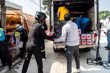 Bangkok, Tayland, 29 Mart 2025. Tayland başkentini deprem vurduktan sonra yıkılan yüksek binadaki kurtarma ekiplerine su ve yiyecek getiren gönüllüler..