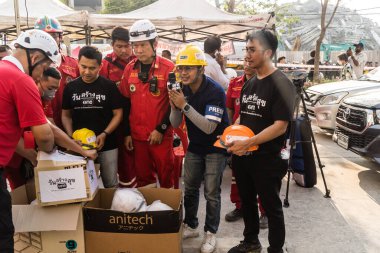 Bangkok, Tayland, 29 Mart 2025. Tayland başkentini deprem vurduktan sonra yıkılan yüksek binadaki kurtarma ekiplerine su ve yiyecek getiren gönüllüler..