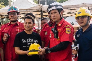Bangkok, Tayland, 29 Mart 2025. Tayland başkentini deprem vurduktan sonra yıkılan yüksek binadaki kurtarma ekiplerine su ve yiyecek getiren gönüllüler..