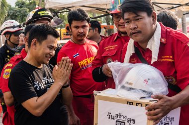 Bangkok, Tayland, 29 Mart 2025. Tayland başkentini deprem vurduktan sonra yıkılan yüksek binadaki kurtarma ekiplerine su ve yiyecek getiren gönüllüler..