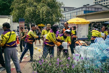 Bangkok, Tayland, 29 Mart 2025. Gönüllüler, Tayland 'daki deprem sonrası yıkılan yüksek binaların inşaatında kurtarma ekipleri için su şişeleri taşıyorlar..