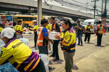 Bangkok, Tayland, 29 Mart 2025. Gönüllüler, Tayland 'daki deprem sonrası yıkılan yüksek binaların inşaatında kurtarma ekipleri için su şişeleri taşıyorlar..