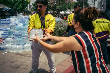 Bangkok, Tayland, 29 Mart 2025. Gönüllüler, Tayland 'daki deprem sonrası yıkılan yüksek binaların inşaatında kurtarma ekipleri için su şişeleri taşıyorlar..
