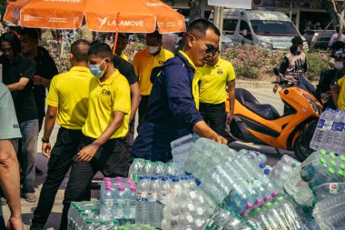 Bangkok, Tayland, 29 Mart 2025. Gönüllüler, Tayland 'daki deprem sonrası yıkılan yüksek binaların inşaatında kurtarma ekipleri için su şişeleri taşıyorlar..
