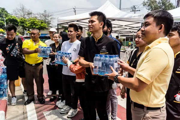 Bangkok, Tayland, 29 Mart 2025. Tayland başkentini deprem vurduktan sonra yıkılan yüksek binadaki kurtarma ekiplerine su ve yiyecek getiren gönüllüler..