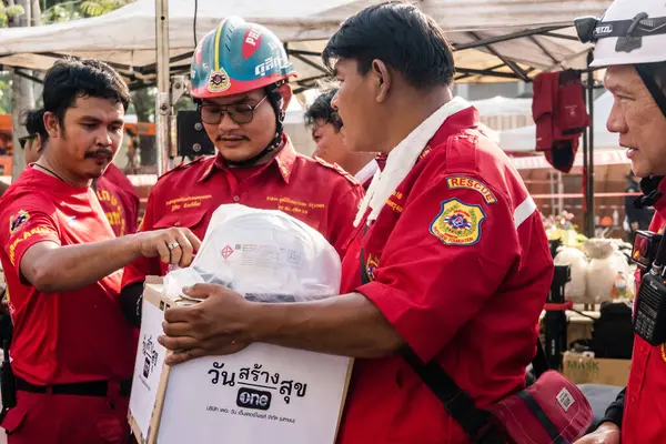Bangkok, Tayland, 29 Mart 2025. Tayland başkentini deprem vurduktan sonra yıkılan yüksek binadaki kurtarma ekiplerine su ve yiyecek getiren gönüllüler..