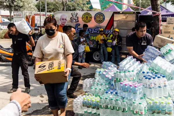 Bangkok, Tayland, 29 Mart 2025. Tayland başkentini deprem vurduktan sonra yıkılan yüksek binadaki kurtarma ekiplerine su ve yiyecek getiren gönüllüler..