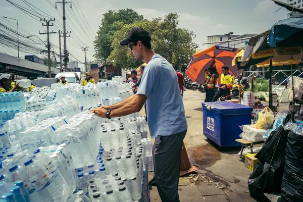 Bangkok, Tayland, 29 Mart 2025. Gönüllüler, Tayland 'daki deprem sonrası yıkılan yüksek binaların inşaatında kurtarma ekipleri için su şişeleri taşıyorlar..
