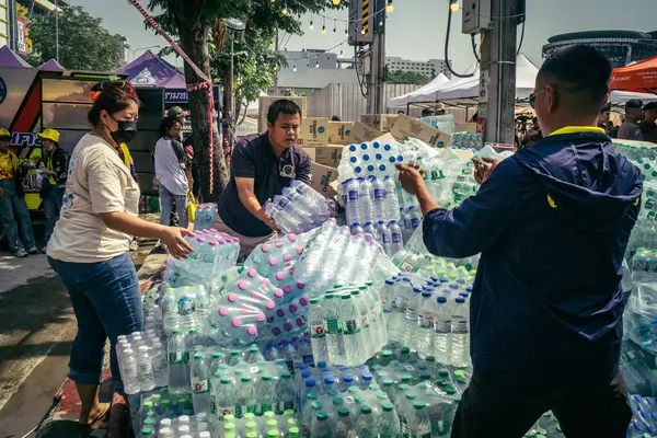 Bangkok, Tayland, 29 Mart 2025. Gönüllüler, Tayland 'daki deprem sonrası yıkılan yüksek binaların inşaatında kurtarma ekipleri için su şişeleri taşıyorlar..