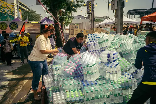 Bangkok, Tayland, 29 Mart 2025. Gönüllüler, Tayland 'daki deprem sonrası yıkılan yüksek binaların inşaatında kurtarma ekipleri için su şişeleri taşıyorlar..