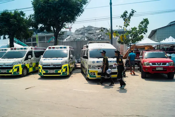 Bangkok, Tayland, 29 Mart 2025. Bangkok 'taki depremden sonra çöken bir binanın inşaat halindeki binasında ambulanslar bulunuyor. Birçok kurban hala enkaz altında..
