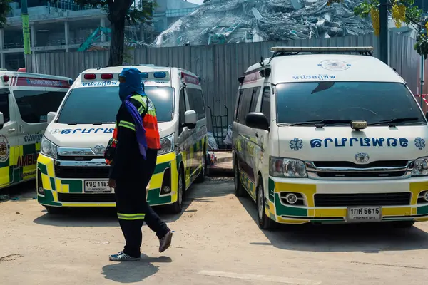 Bangkok, Tayland, 29 Mart 2025. Bangkok 'taki depremden sonra çöken bir binanın inşaat halindeki binasında ambulanslar bulunuyor. Birçok kurban hala enkaz altında..