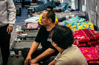 Bangkok, Tayland, Nisan 02, 2025. Kayıp işçilerin yakınları, depremin Tayland başkentini vurmasından sonra çöken yüksek binaların bulunduğu bir çadırda bekliyorlar..