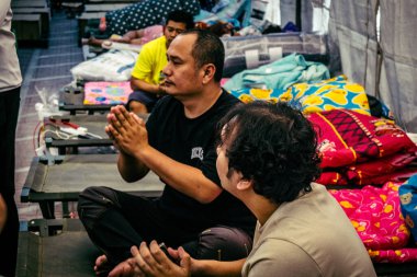 Bangkok, Tayland, Nisan 02, 2025. Kayıp işçilerin yakınları, depremin Tayland başkentini vurmasından sonra çöken yüksek binaların bulunduğu bir çadırda bekliyorlar..