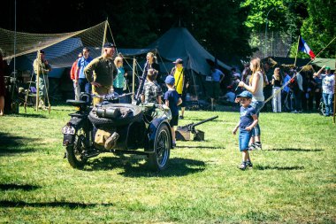 Reims, Fransa, 10 Mayıs 2025. Dünya Savaşı 'ndan kalma kostümlü insanlar, araçlar, silahlar, lojistik ve dönem aksesuarlarıyla 1945 Amerikan Müttefik askeri kampının tarihi yeniden canlandırmasını ziyaret etti.
