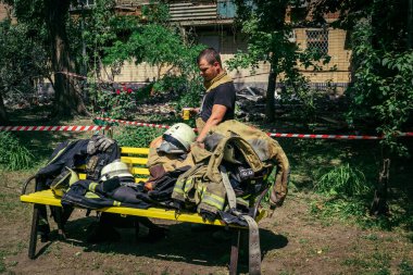 Kharkiv, Ukrayna, 7 Haziran 2025. İtfaiyeciler, Harkiv 'deki bir yerleşim yerine yapılan Rus saldırısından sonra dinleniyorlar. Birçok apartman yangını ve pencerenin tahrip olmasıyla hasar büyük..