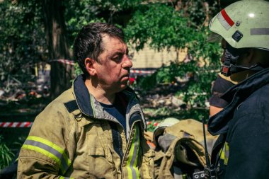 Kharkiv, Ukrayna, 7 Haziran 2025. İtfaiyeciler, Harkiv 'deki bir yerleşim yerine yapılan Rus saldırısından sonra dinleniyorlar. Birçok apartman yangını ve pencerenin tahrip olmasıyla hasar büyük..