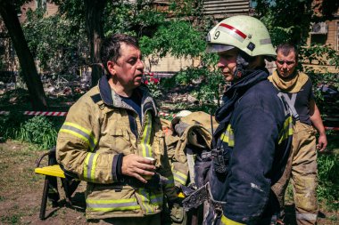 Kharkiv, Ukrayna, 7 Haziran 2025. İtfaiyeciler, Harkiv 'deki bir yerleşim yerine yapılan Rus saldırısından sonra dinleniyorlar. Birçok apartman yangını ve pencerenin tahrip olmasıyla hasar büyük..