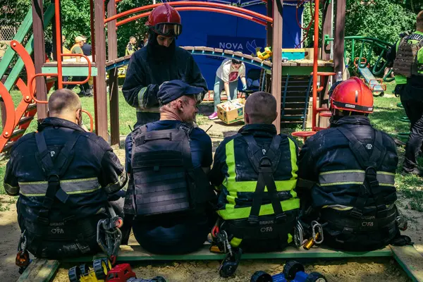 Kharkiv, Ukrayna, 7 Haziran 2025. İtfaiyeciler, Harkiv 'deki bir yerleşim yerine yapılan Rus saldırısından sonra dinleniyorlar. Birçok apartman yangını ve pencerenin tahrip olmasıyla hasar büyük..