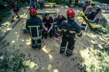 Kharkiv, Ukrayna, 7 Haziran 2025. İtfaiyeciler, Harkiv 'deki bir yerleşim yerine yapılan Rus saldırısından sonra dinleniyorlar. Birçok apartman yangını ve pencerenin tahrip olmasıyla hasar büyük..
