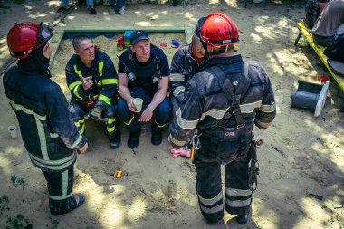 Kharkiv, Ukrayna, 7 Haziran 2025. İtfaiyeciler, Harkiv 'deki bir yerleşim yerine yapılan Rus saldırısından sonra dinleniyorlar. Birçok apartman yangını ve pencerenin tahrip olmasıyla hasar büyük..
