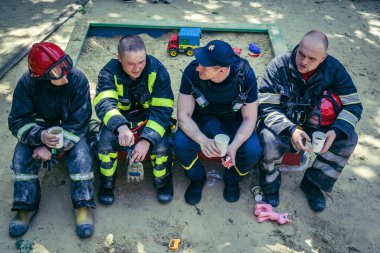 Kharkiv, Ukrayna, 7 Haziran 2025. İtfaiyeciler, Harkiv 'deki bir yerleşim yerine yapılan Rus saldırısından sonra dinleniyorlar. Birçok apartman yangını ve pencerenin tahrip olmasıyla hasar büyük..