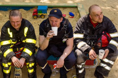 Kharkiv, Ukrayna, 7 Haziran 2025. İtfaiyeciler, Harkiv 'deki bir yerleşim yerine yapılan Rus saldırısından sonra dinleniyorlar. Birçok apartman yangını ve pencerenin tahrip olmasıyla hasar büyük..