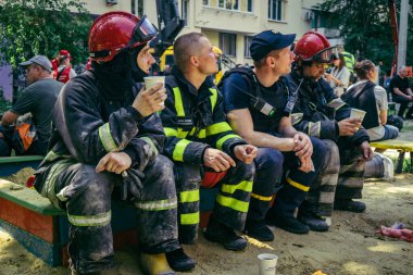 Kharkiv, Ukrayna, 7 Haziran 2025. İtfaiyeciler, Harkiv 'deki bir yerleşim yerine yapılan Rus saldırısından sonra dinleniyorlar. Birçok apartman yangını ve pencerenin tahrip olmasıyla hasar büyük..