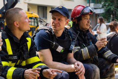 Kharkiv, Ukrayna, 7 Haziran 2025. İtfaiyeciler, Harkiv 'deki bir yerleşim yerine yapılan Rus saldırısından sonra dinleniyorlar. Birçok apartman yangını ve pencerenin tahrip olmasıyla hasar büyük..