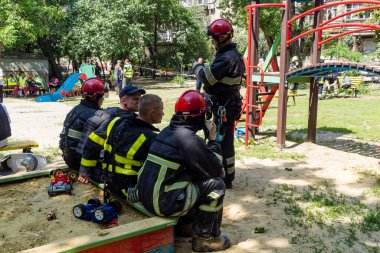 Kharkiv, Ukrayna, 7 Haziran 2025. İtfaiyeciler, Harkiv 'deki bir yerleşim yerine yapılan Rus saldırısından sonra dinleniyorlar. Birçok apartman yangını ve pencerenin tahrip olmasıyla hasar büyük..