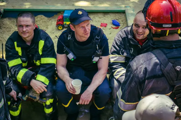 Kharkiv, Ukrayna, 7 Haziran 2025. İtfaiyeciler, Harkiv 'deki bir yerleşim yerine yapılan Rus saldırısından sonra dinleniyorlar. Birçok apartman yangını ve pencerenin tahrip olmasıyla hasar büyük..