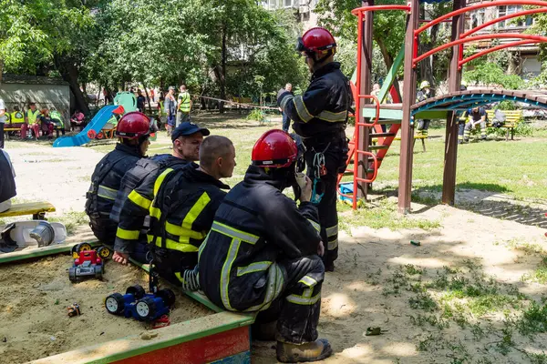 Kharkiv, Ukrayna, 7 Haziran 2025. İtfaiyeciler, Harkiv 'deki bir yerleşim yerine yapılan Rus saldırısından sonra dinleniyorlar. Birçok apartman yangını ve pencerenin tahrip olmasıyla hasar büyük..