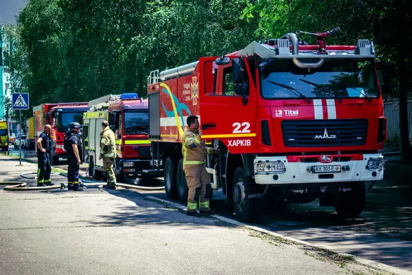 Kharkiv, Ukrayna, 7 Haziran 2025, Harkiv 'deki hasarlı binanın yakınına itfaiye araçları park edilmiştir. Hasar büyük, birkaç apartman yanıyor ve birçok pencere yıkıldı..