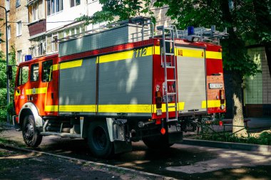 Kharkiv, Ukrayna, 7 Haziran 2025, Harkiv 'deki hasarlı binanın yakınına itfaiye araçları park edilmiştir. Hasar büyük, birkaç apartman yanıyor ve birçok pencere yıkıldı..