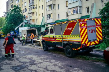 Kharkiv, Ukrayna, 7 Haziran 2025, Harkiv 'deki hasarlı binanın yakınına itfaiye araçları park edilmiştir. Hasar büyük, birkaç apartman yanıyor ve birçok pencere yıkıldı..